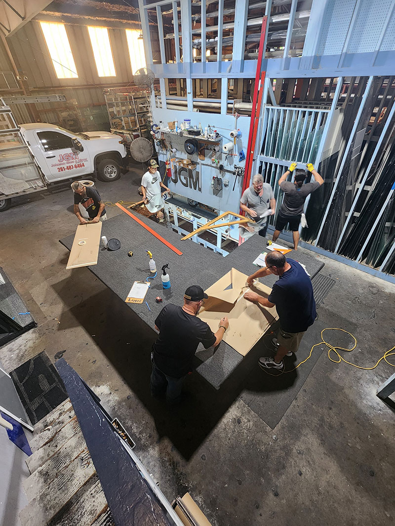 JGM employees cutting glass TEAM WORK